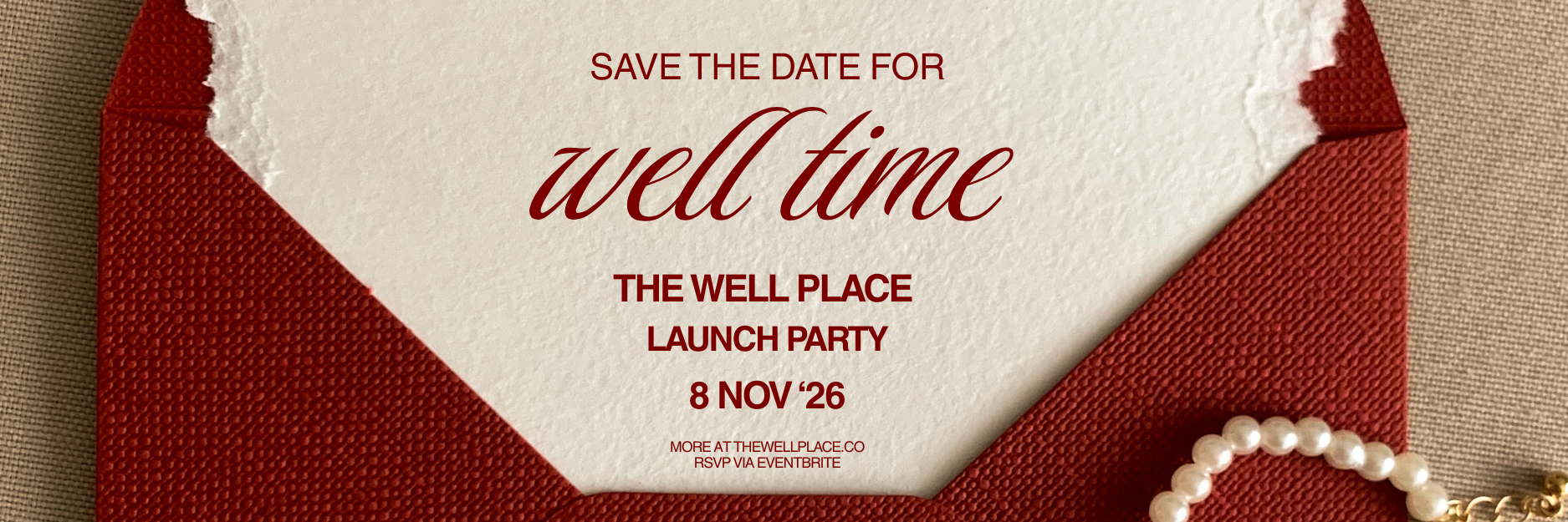 Save the date for Well Time, November 8, 2026. An invitation on cream paper with a deep red envelope and pearls.