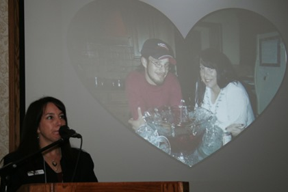Johanna LeRoux at a podium speaking to a group of employees on the devistating impacts of workplace tragedies and the importance of workplace safety and injury prevention.