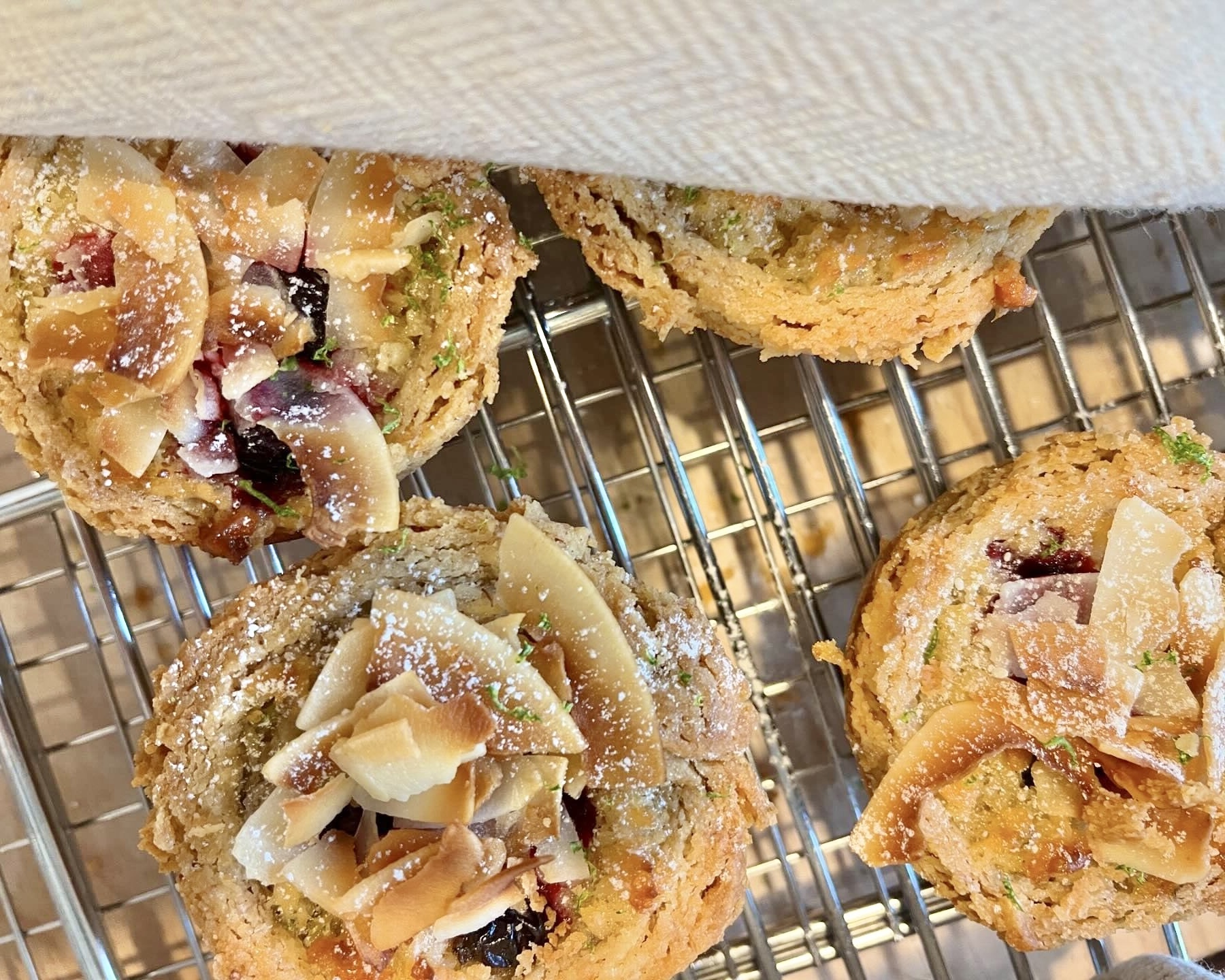 Overhead view of Blackcurrant, Coconut and Lime Tartlets on cooling rack.