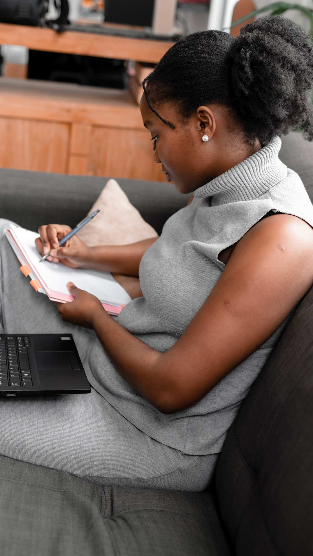 Black woman creating a personalized self-care and life strategy plan—writing action steps to overcome burnout and reclaim rest