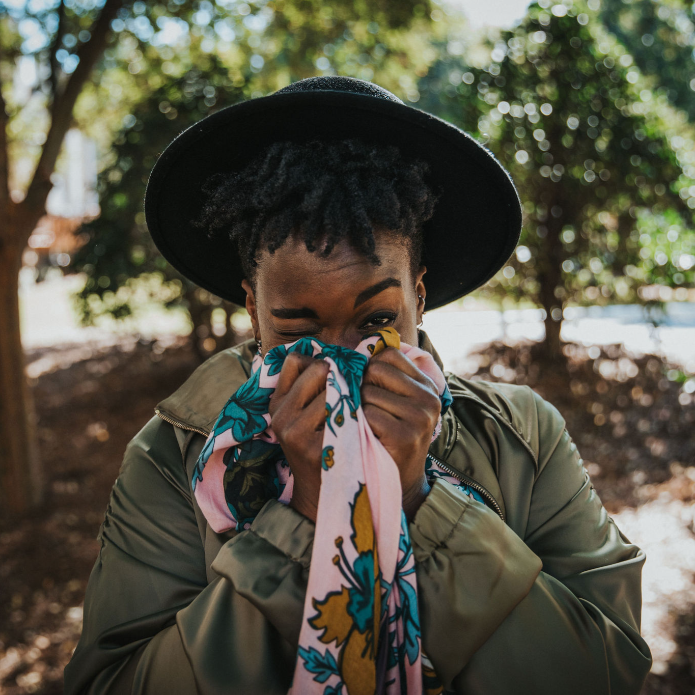 Rashidat smiling playfully while wrapped in a floral scarf — a relatable moment from a Black life coach helping strong Black women and boss babes embrace rest, alignment, and the soft girl era.