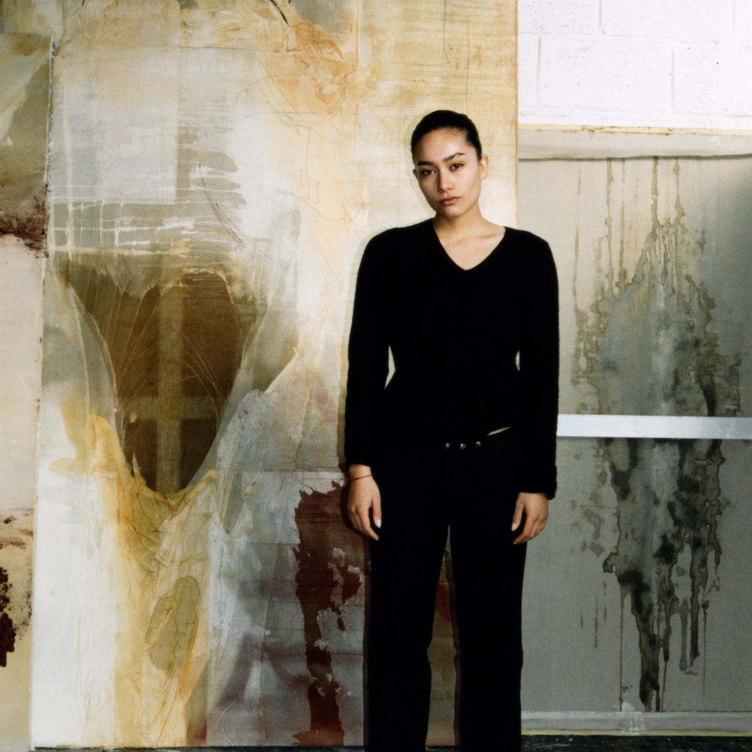 Kadr z filmu przedstawiający postać kobiecą stojącą przy mikrofonie.