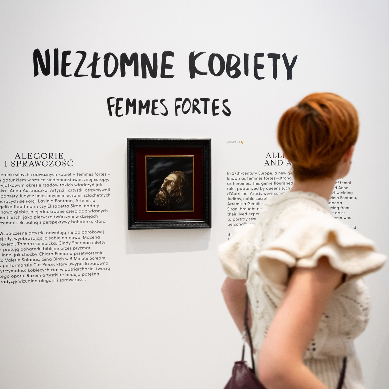 Kadr z filmu przedstawiający postać kobiecą stojącą przy mikrofonie.