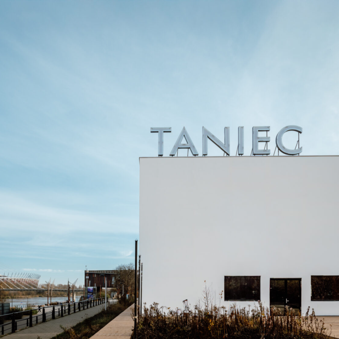 Kadr z filmu przedstawiający postać kobiecą stojącą przy mikrofonie.