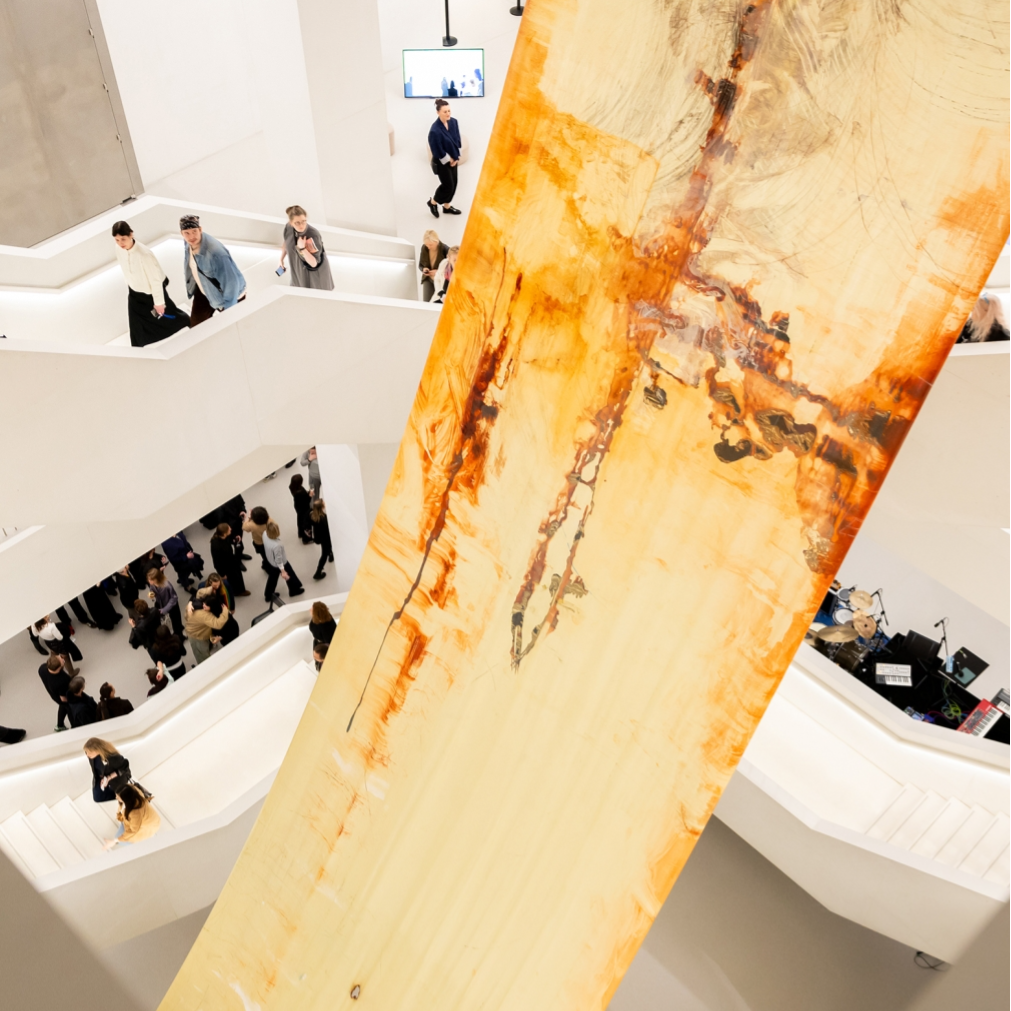 Kadr z filmu przedstawiający postać kobiecą stojącą przy mikrofonie.