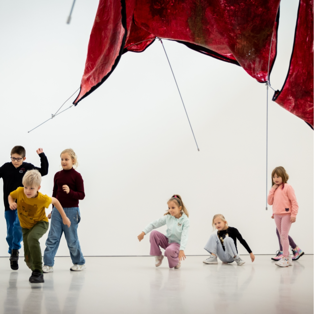 Kadr z filmu przedstawiający postać kobiecą stojącą przy mikrofonie.