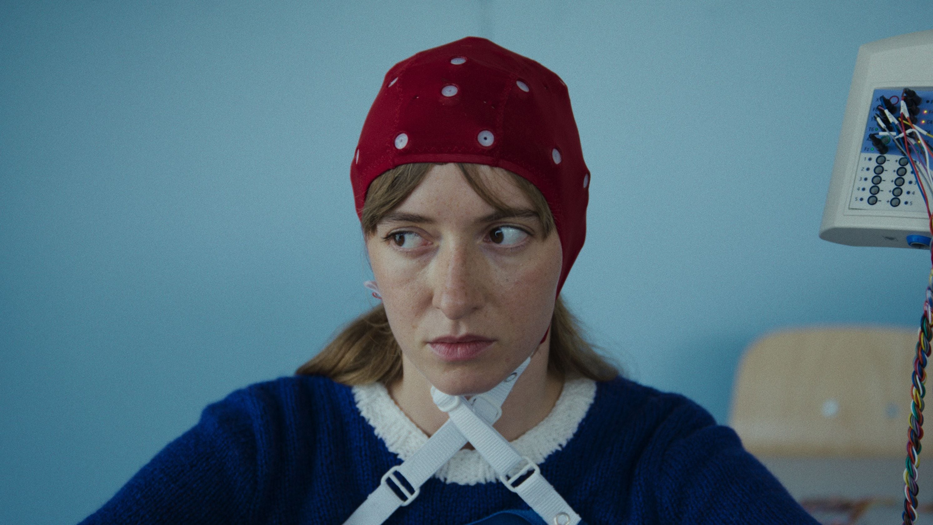 Kadr z filmu przedstawiający postać kobiecą stojącą przy mikrofonie.