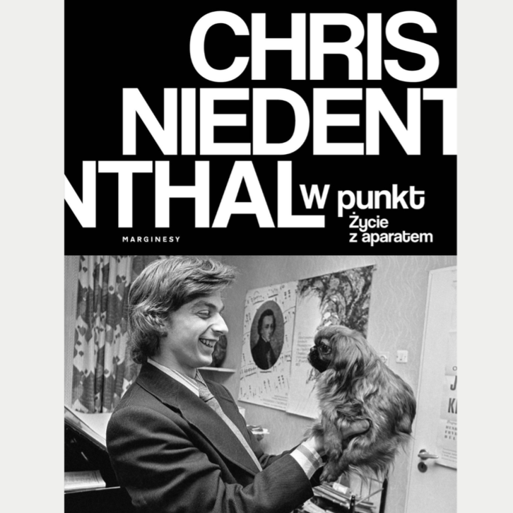 Kadr z filmu przedstawiający postać kobiecą stojącą przy mikrofonie.