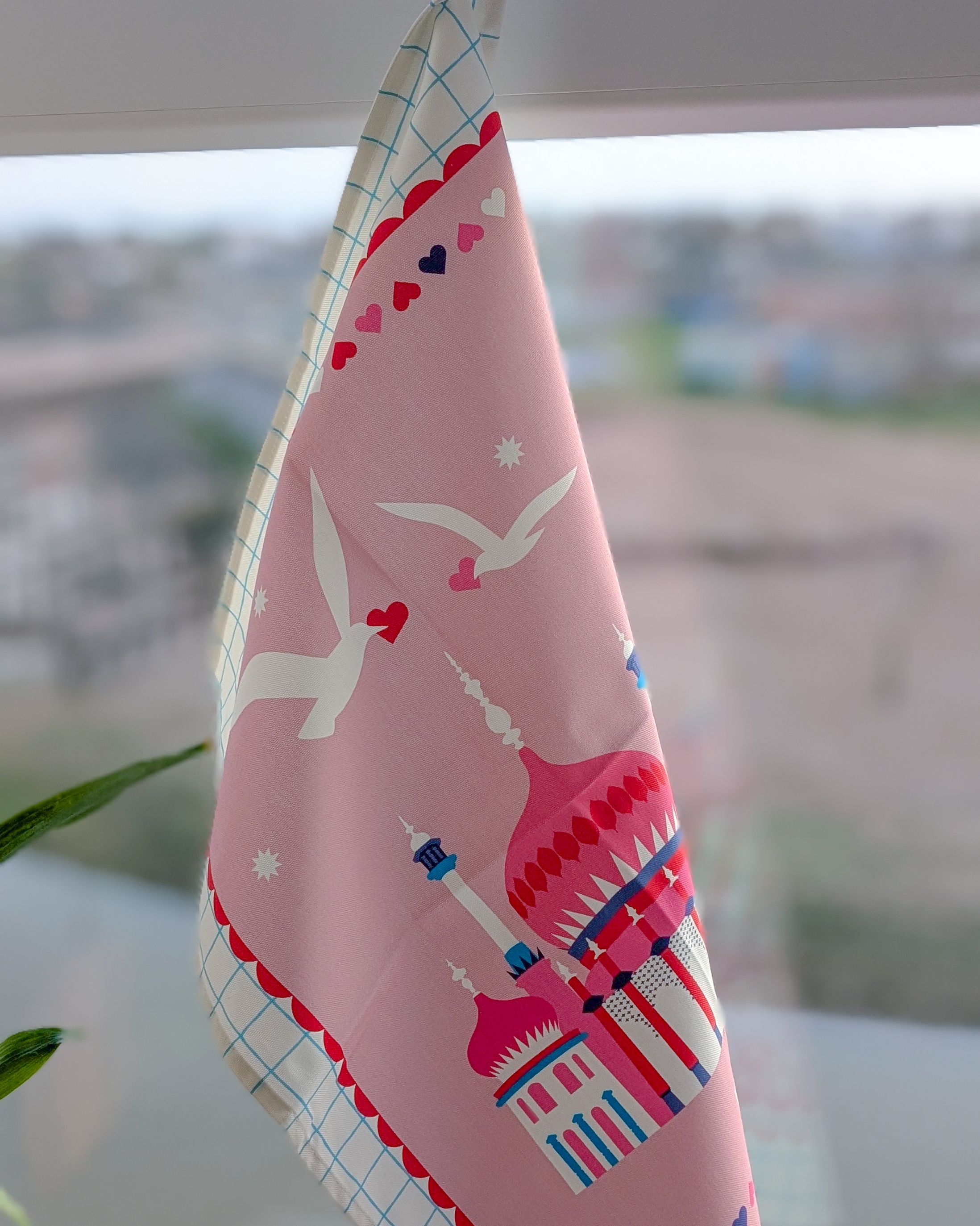 A hand holding a print showing white cliffs, a sunset and seagulls