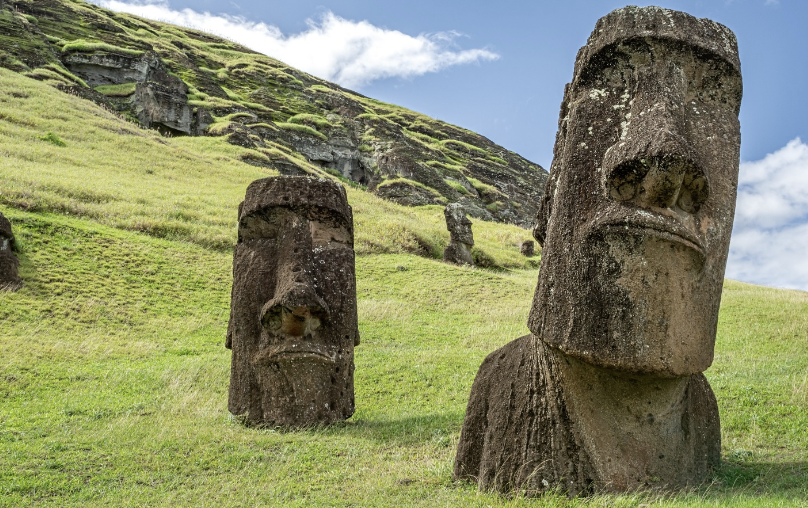 two totem statues on a grassy hillside
