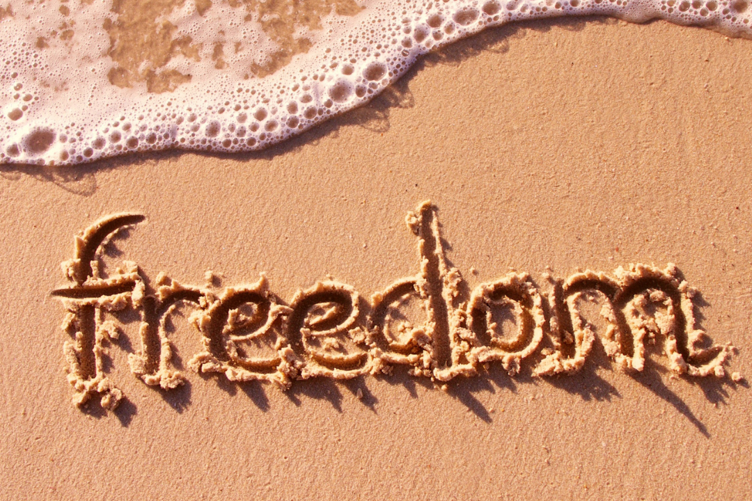 Beach with the word freedom entered in the sand