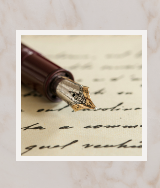 a paper with cursive writing and a fountain pen