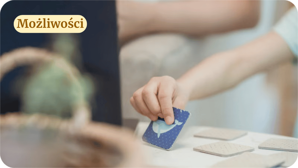 Dziecko odwraca kartę znajdującą się na stole