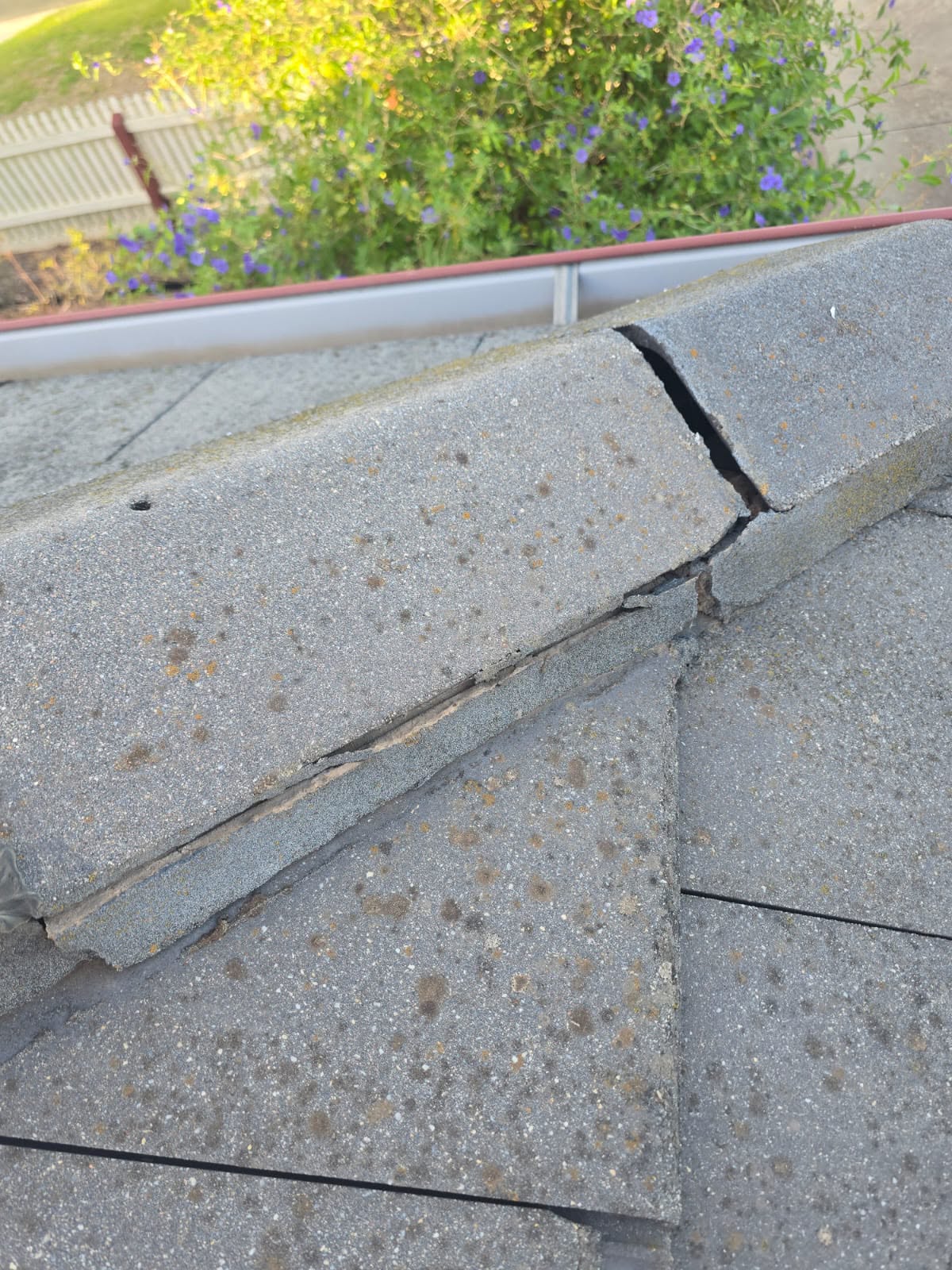 Cracked ridge capping on a tiled roof before repair