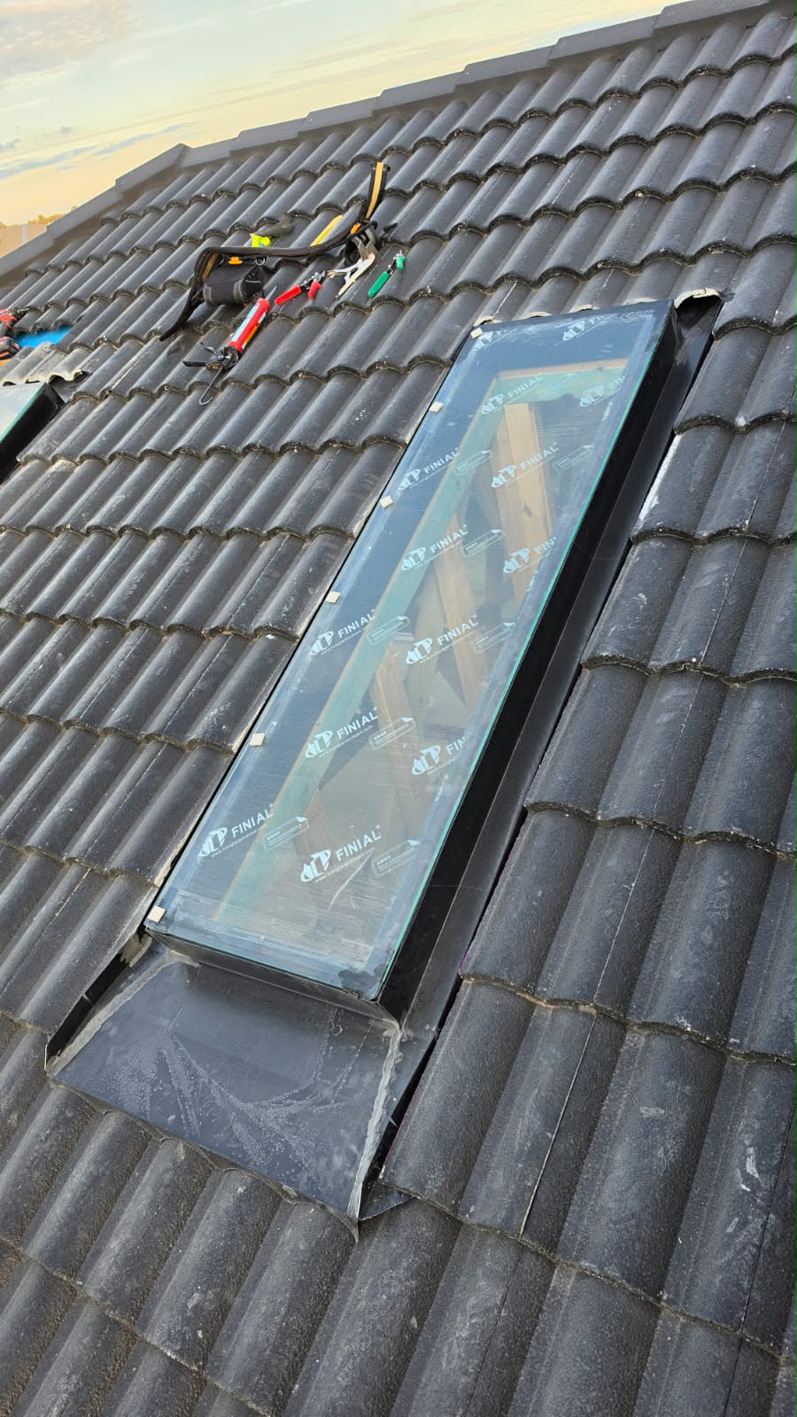 Finished skylight sitting neatly in a grey tiled roof