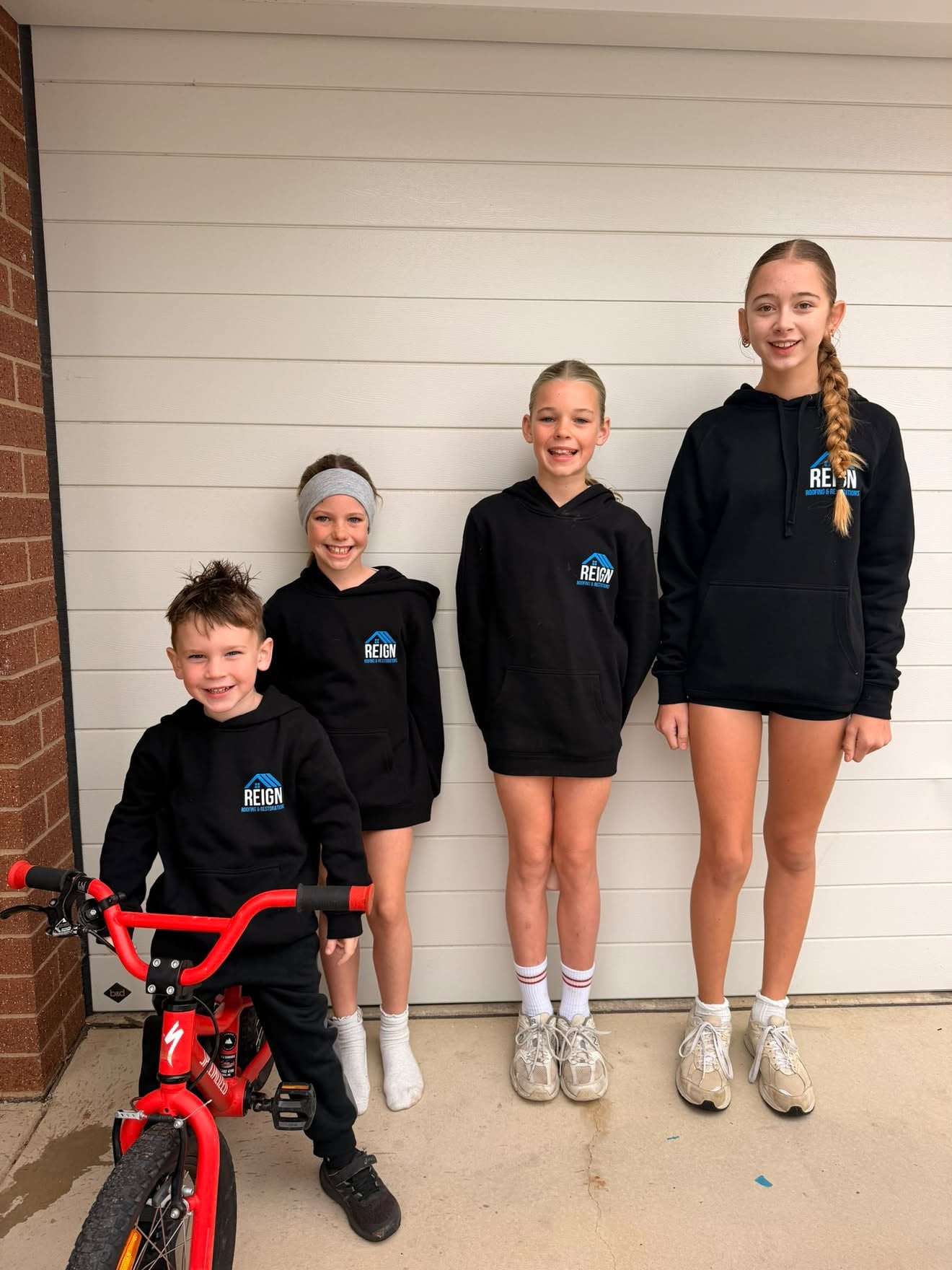 The Holland kids wearing their Reign Roofing jumpers