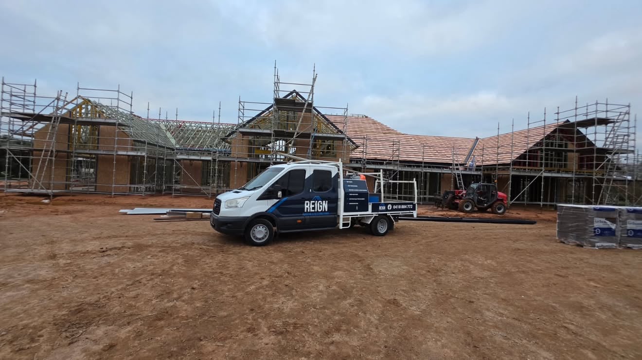 Reign Roofing ute parked at a new home build site