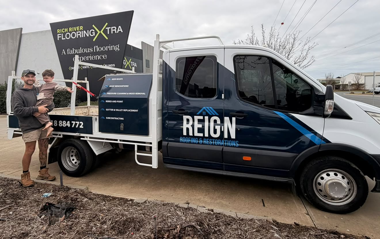Michael Holland with his youngest son Alvi beside the Reign Roofing work ute