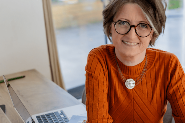 Zwei Kinder, die auf einer Mauerkante sitzen. Man sieht sie von hinten.