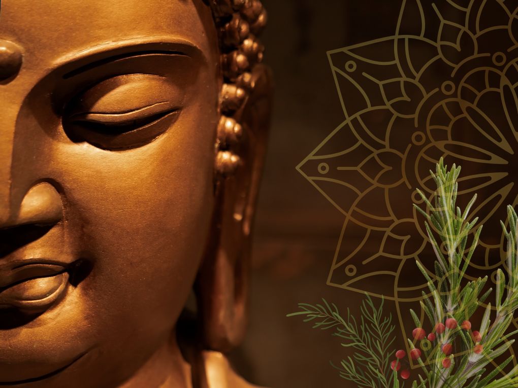 Bronze color close up of buddha statue with evergreen sprigs and red berries.
