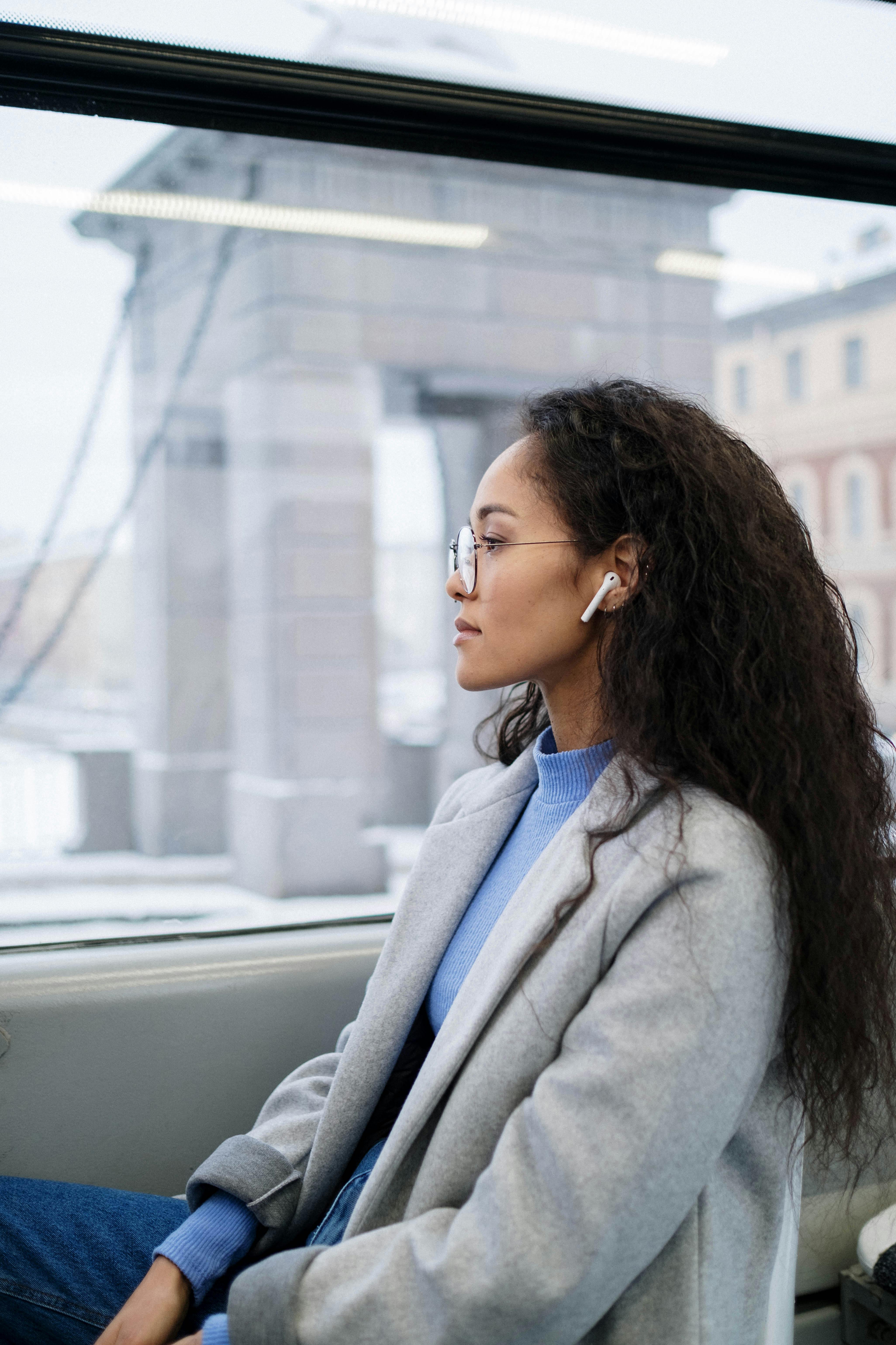 woman looking out window with earphones