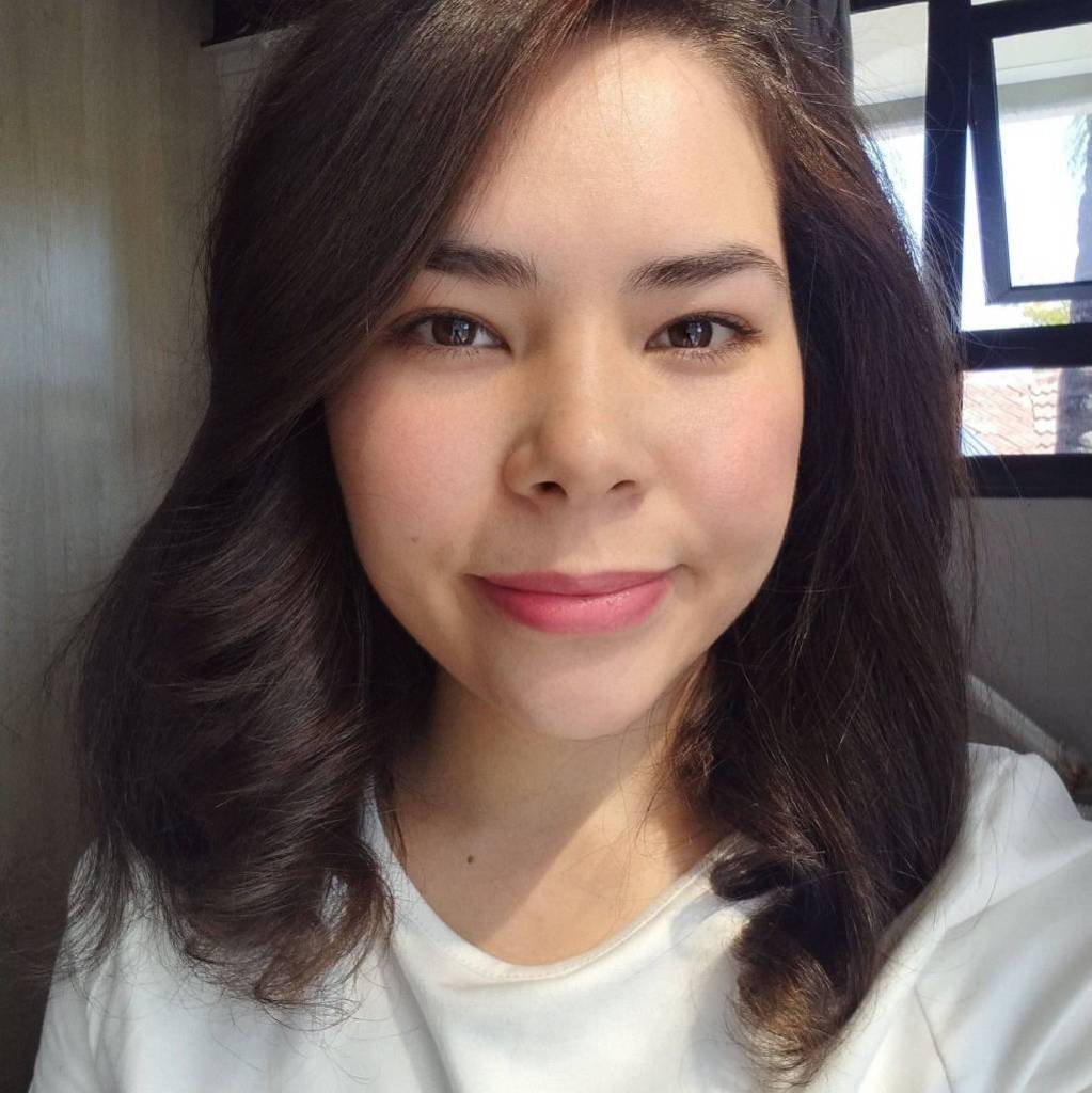 Miranda-Roza, professional vocal coach and singing teacher, smiling in a portrait photo for her online singing lessons and vocal health coaching website.