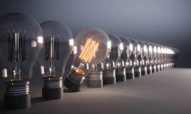 One light bulb on standing out in a group with business ideas.