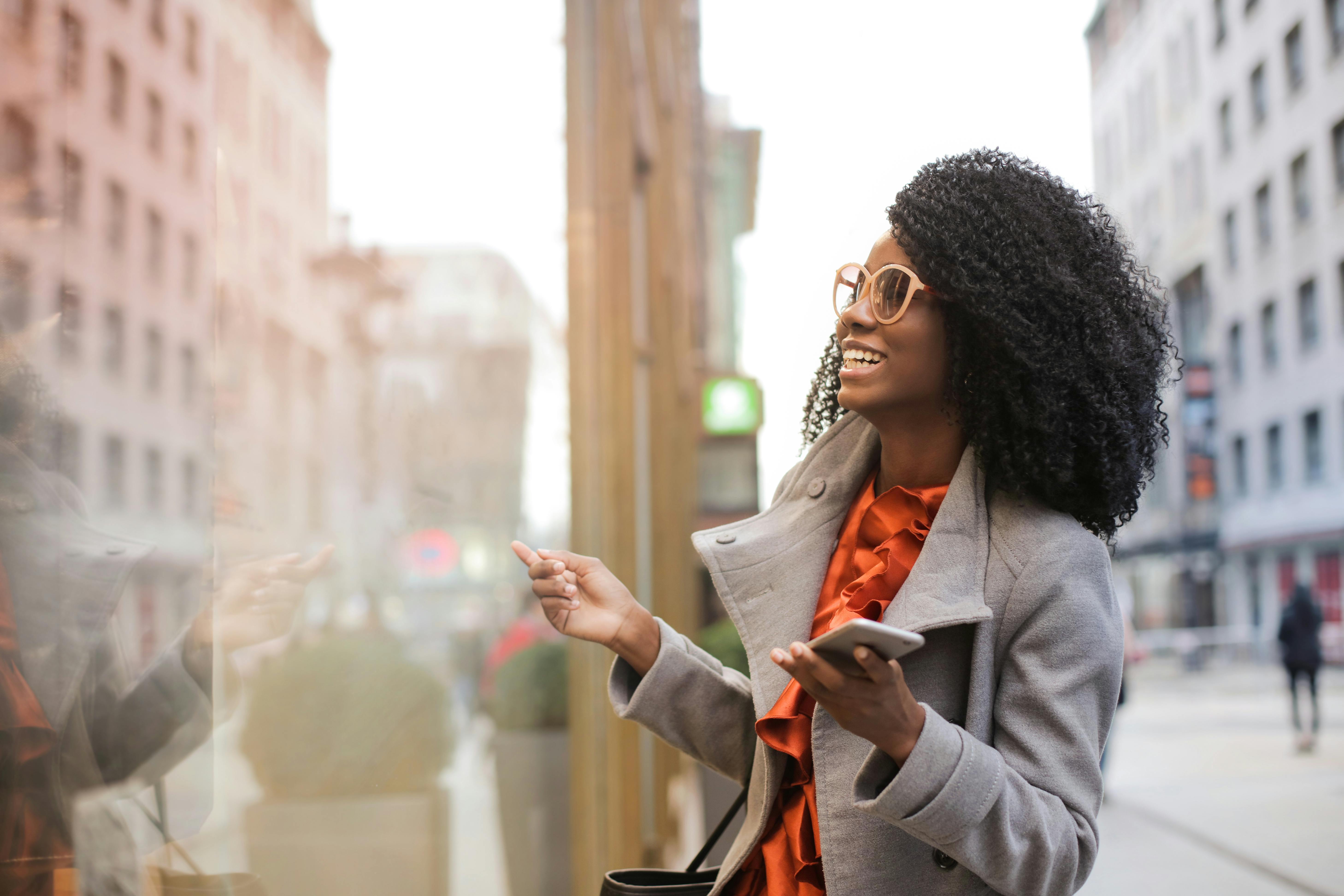 Photo by Andrea Piacquadio: happy black woman smiling on city street.