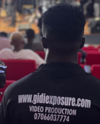 A branded vest with"WWW.GIDI EXPOSURE.COM printed on the back,worn by team member of gidiexposure team during a video coverage