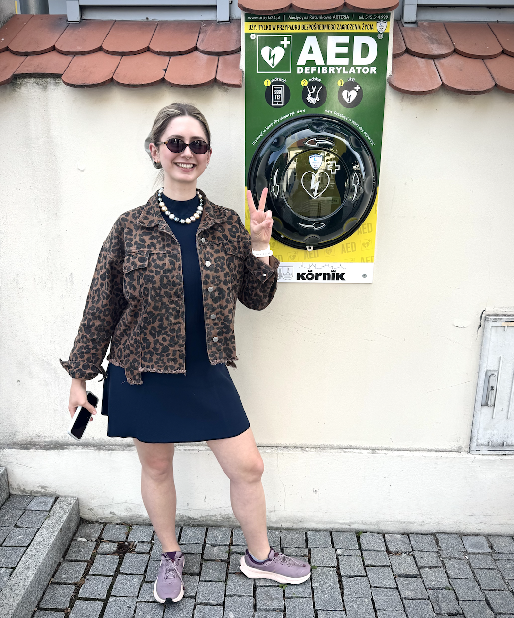 dziewczyna w sukience pozuje z defibrylatorem