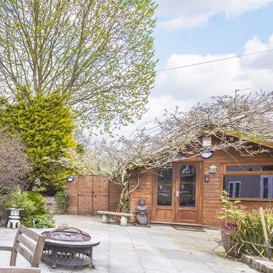 Bespoke built garden cabin for home salon, man-cave, home gym, craft room, outdoor room. Garden shed purpose built in garden with firepit and shrubbery.