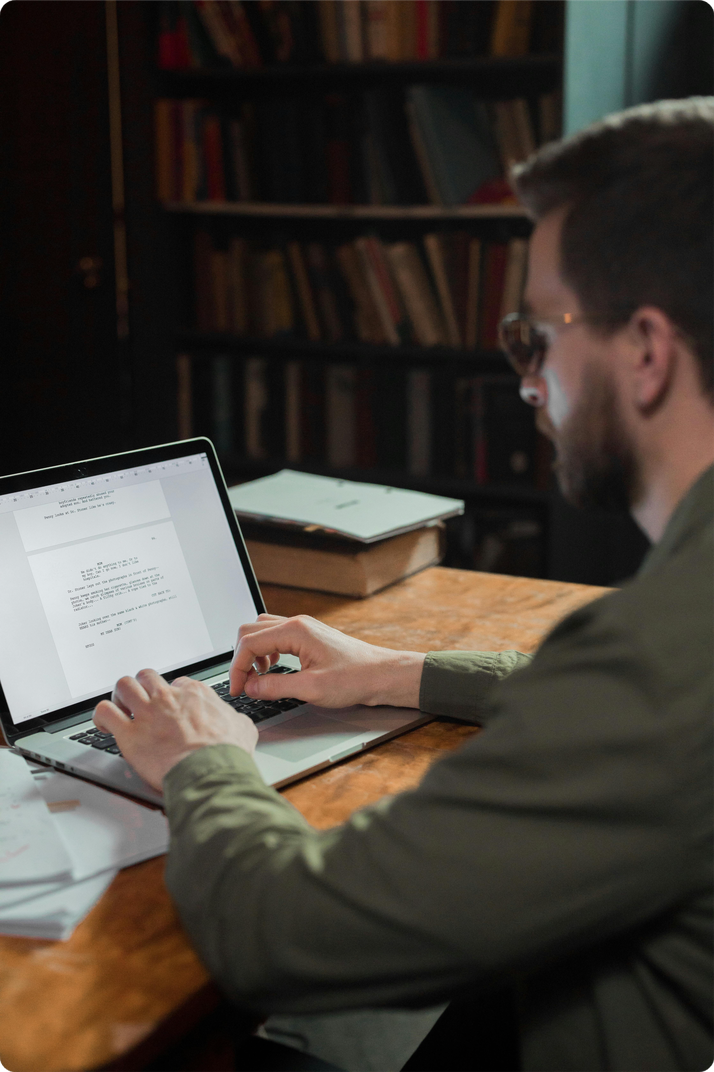 Freelance digital marketer building an email campaign surrounded by books and strategy notes