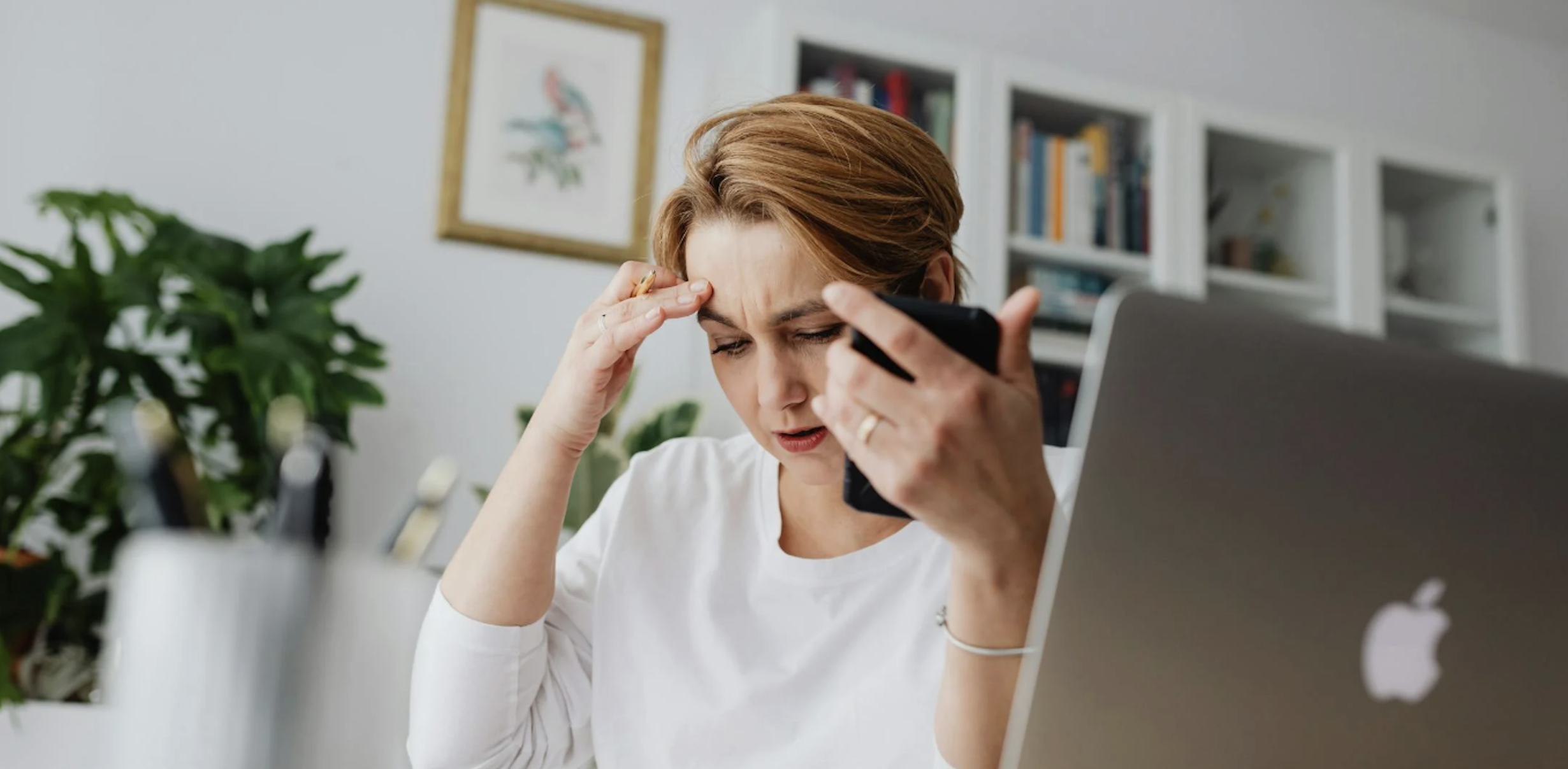 woman at desk feeling overwhelmed from the hustle of being a business owner