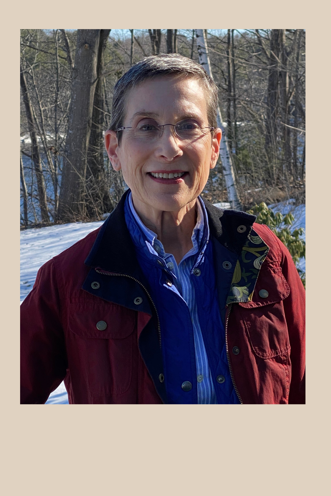 Headshot of Maggie Hoffman. Middle aged woman with short hair. Standing outdoors. Wearing a red jacket.