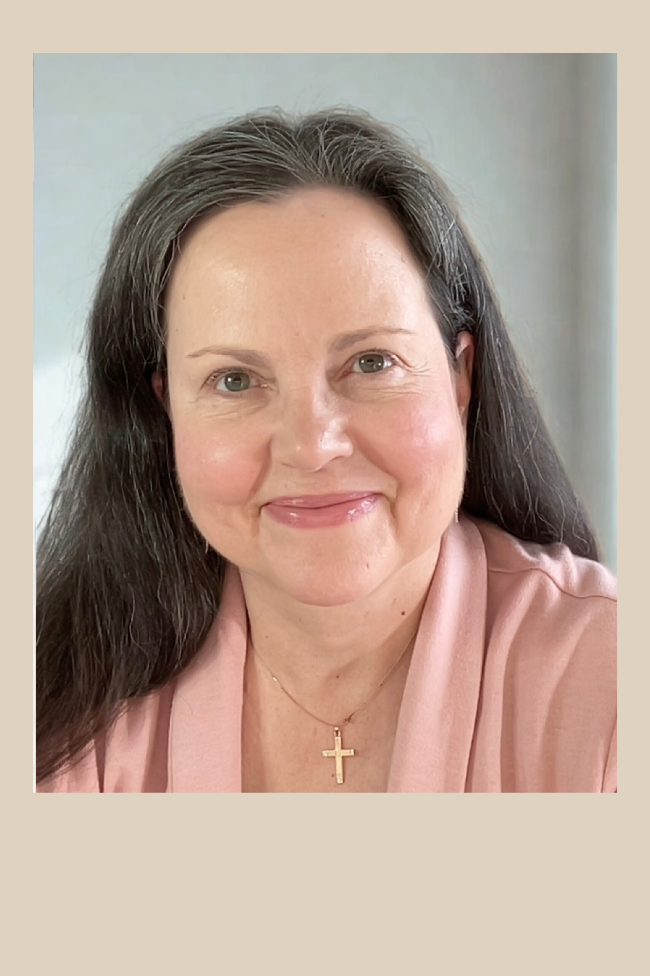 Headshot of Rita Young. A middle aged woman with dark long hair. She has a grin. She is wearing a pink sweater.