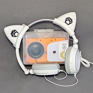 Orange cassette player with built-in speaker and white cat ear headphones with paw print accents