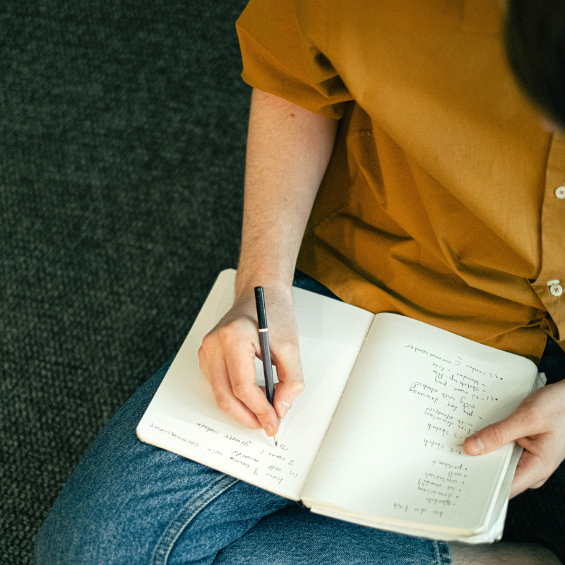 Woman in yellow top writing in notebook - Your Final Matters Letter of Wishes guided writing framework