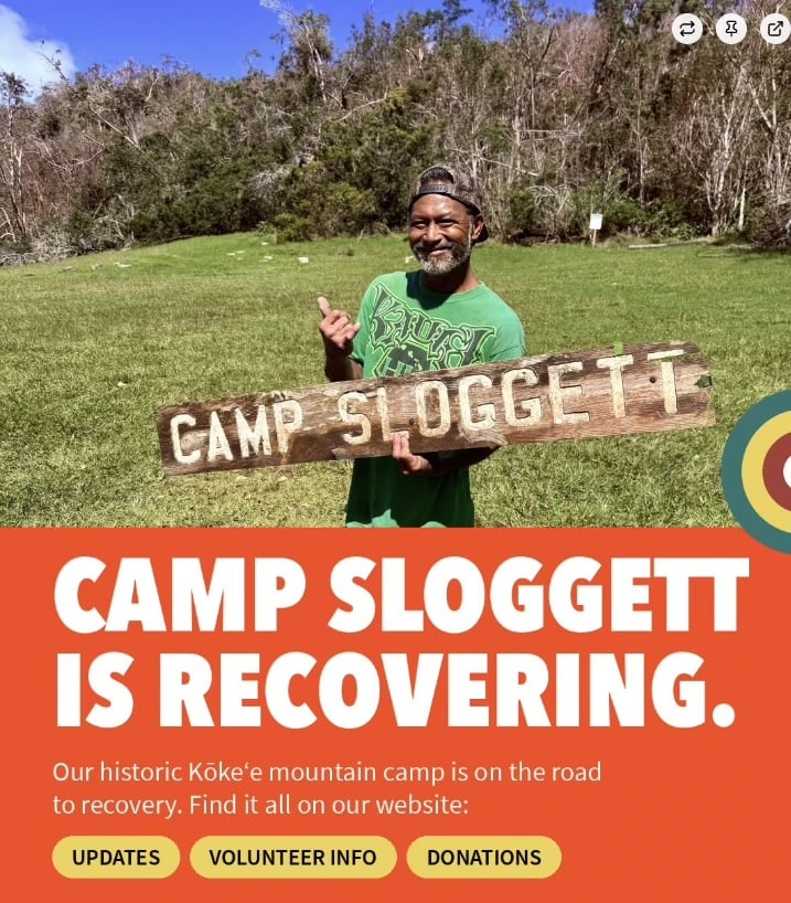 A volunteer holds the weathered Camp Sloggett sign in Kōkeʻe