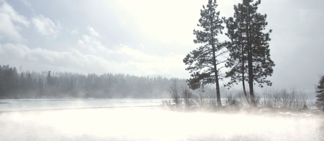 Mist rising off a still lake at sunrise