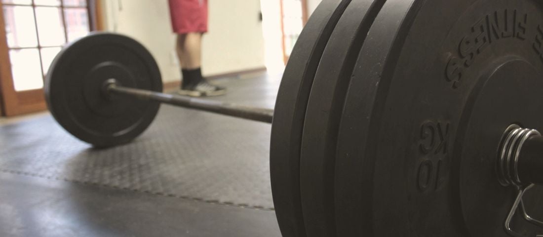 A barbell on a gym floor: two days of weights, most days of walking
