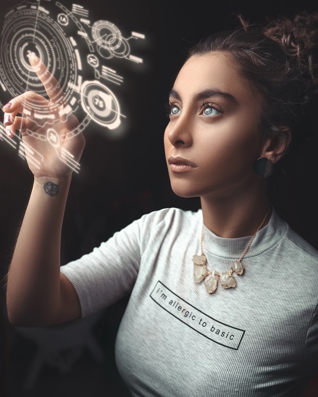 Młoda kobieta manipuluje palcami hologram schematu technicznego