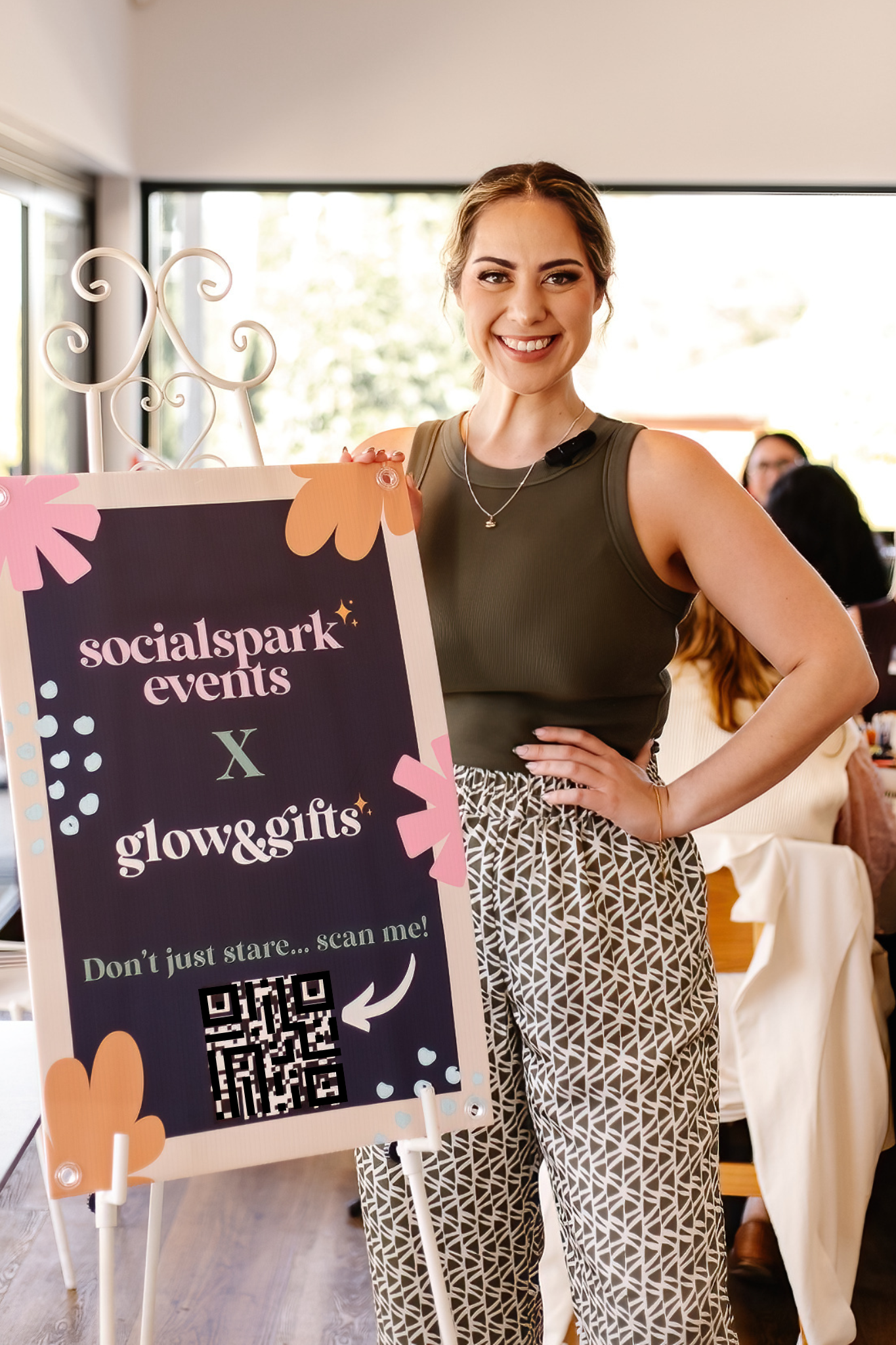 woman standing next to sign labelled with business name and qr code