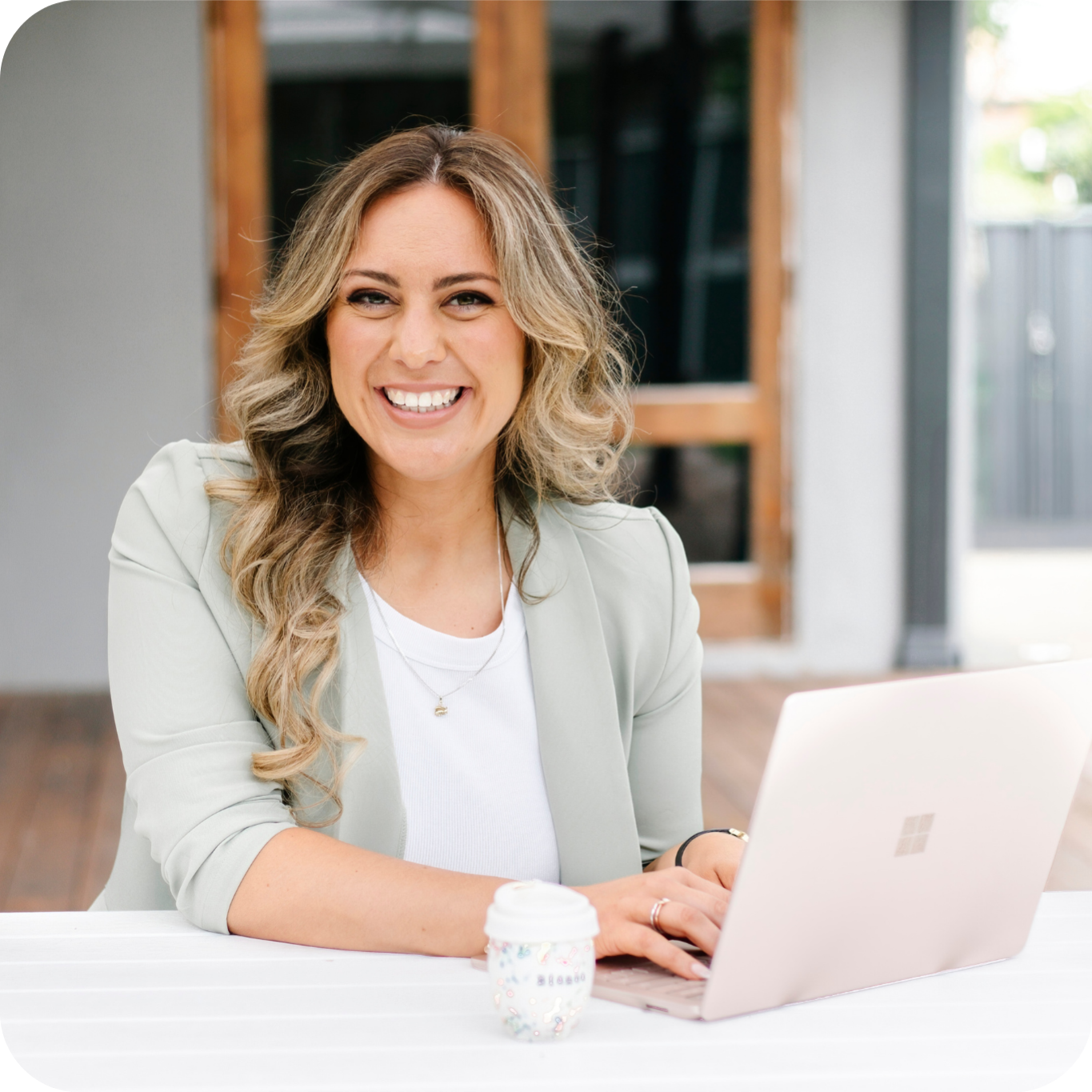Virtual Assistant Bianca Carlino sitting at table, typing on laptop