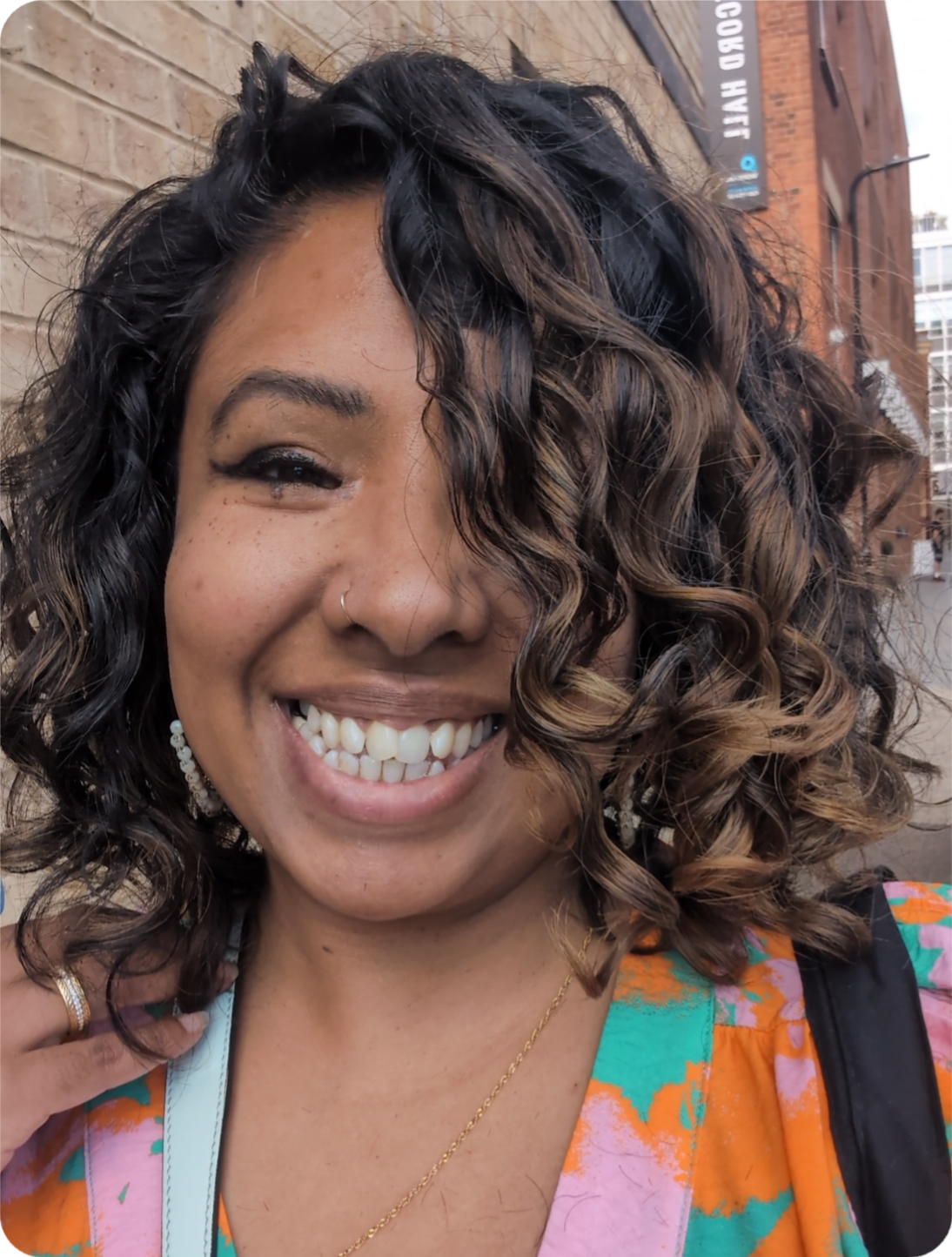 Farhana Aboo smiling outdoors, conveying confidence and approachability as a mindset coach