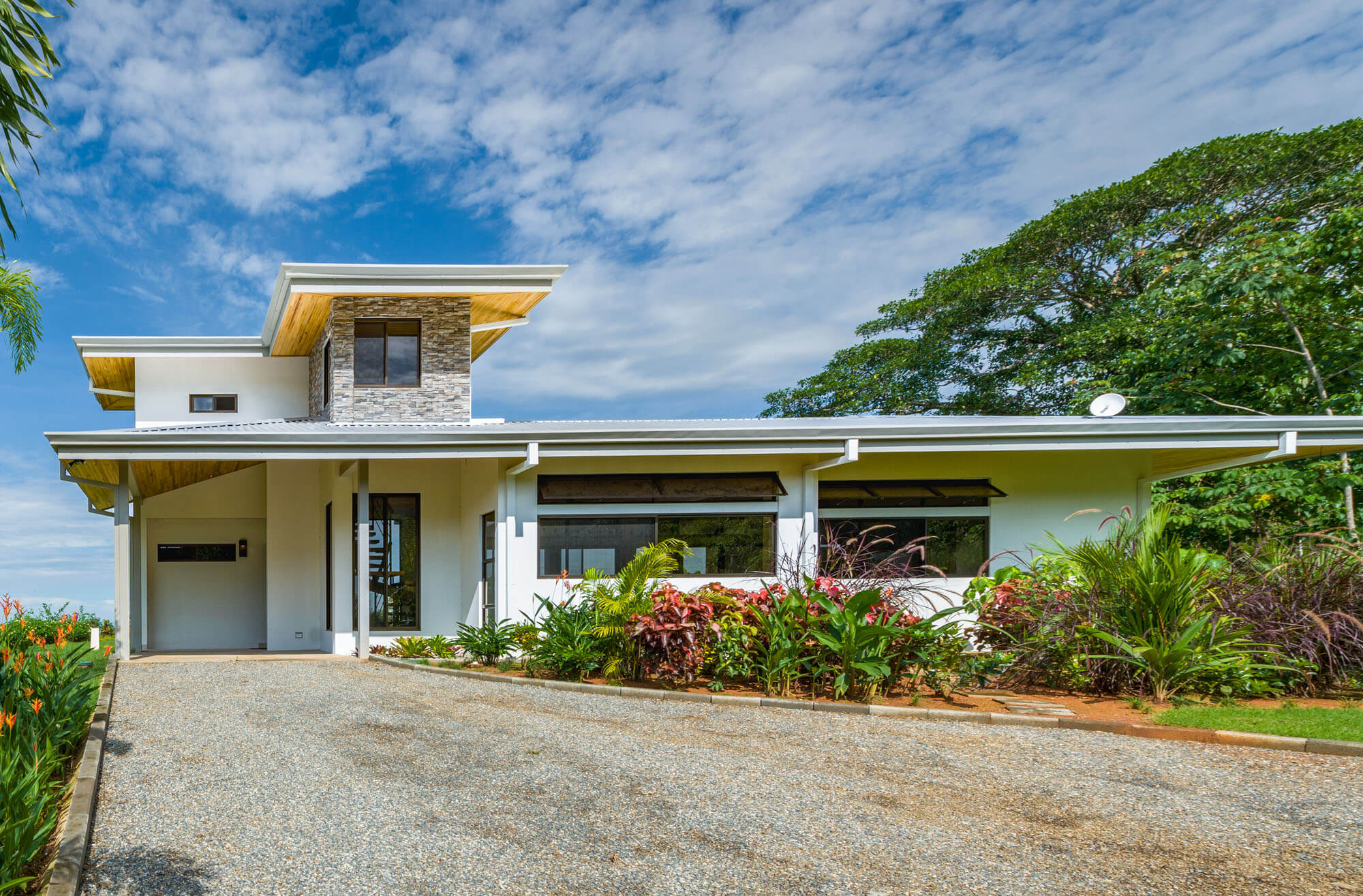 Stunning model home facade with tropical landscaping