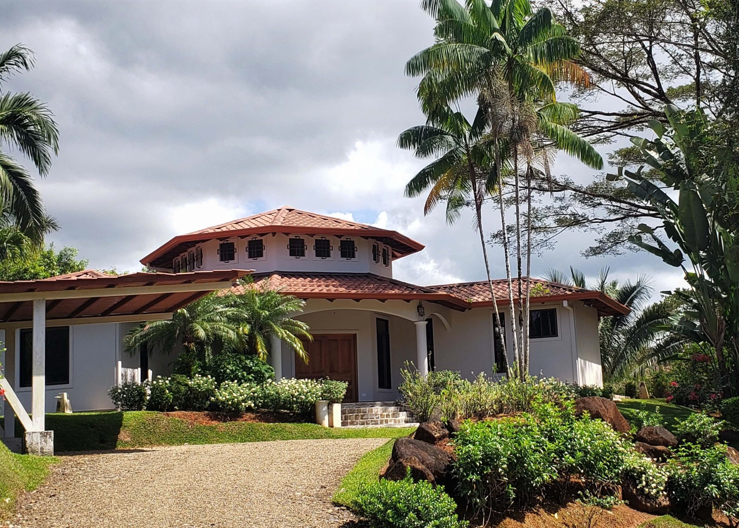 Elegant white home with red tile roof at Green Tropics
