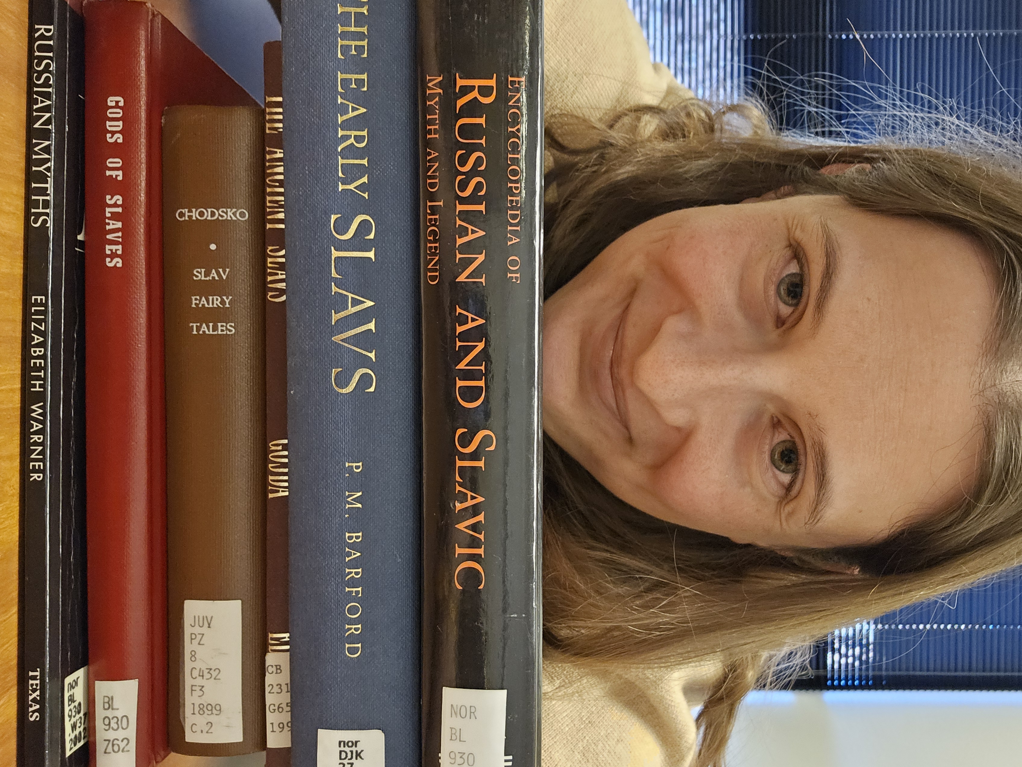woman with chin on stack of books