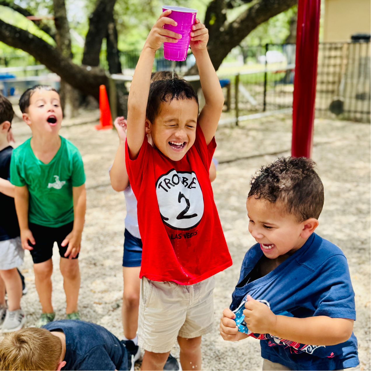 Preschooler splashing water and having fun at camp.