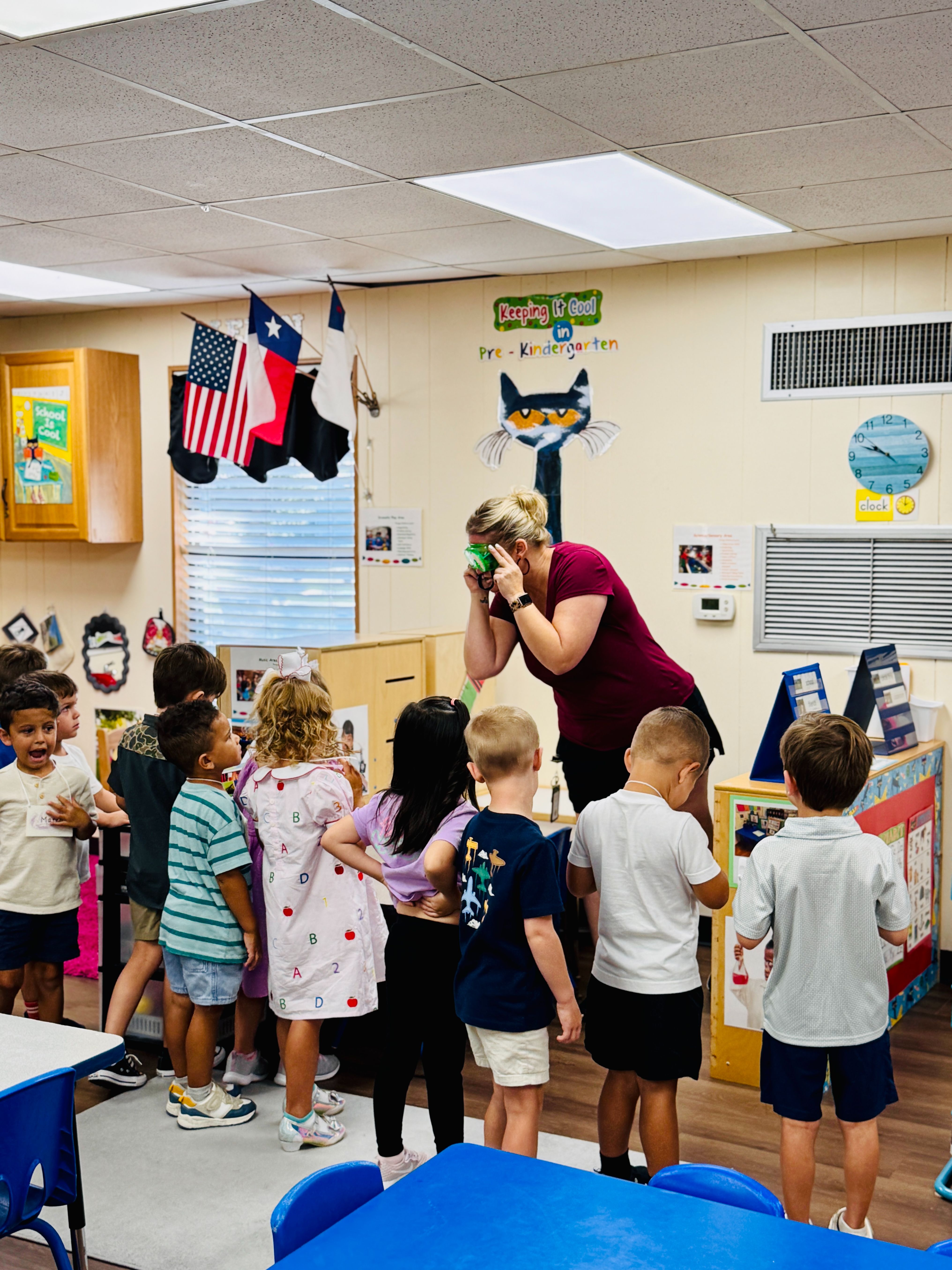 Preschool teacher guiding the children through the new classroom materials.