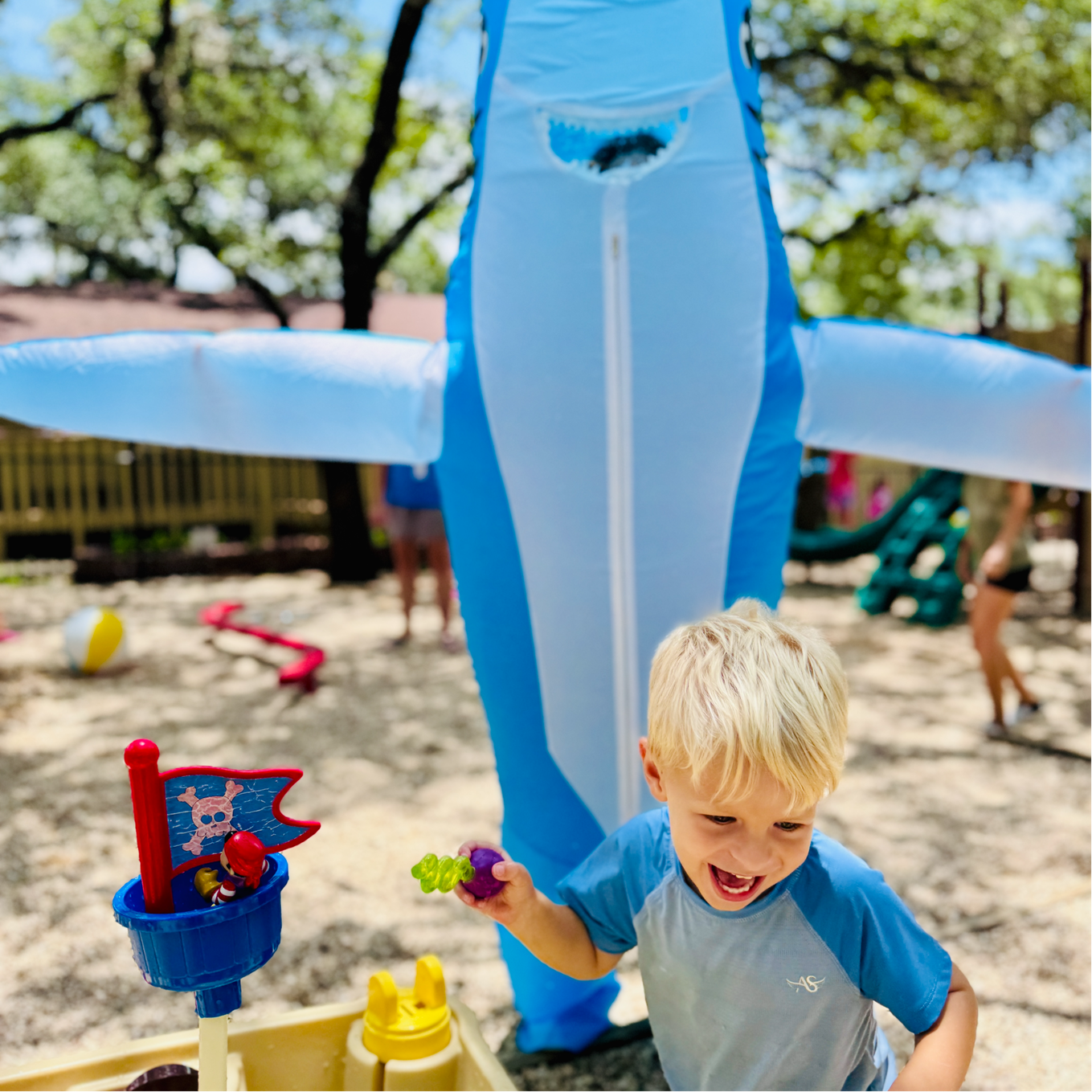 Preschool child doing water play at summer camp.
